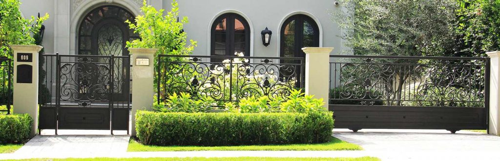 Black wrought iron and sheet metal sliding gate and hinged pedestrian gate