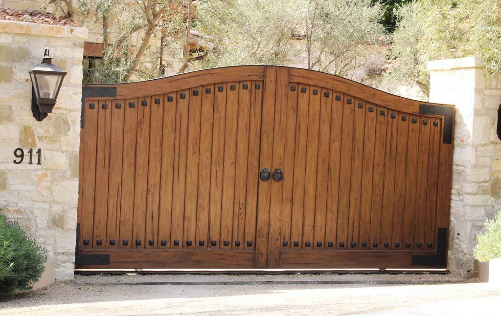 Custom finished exotic hardwood single sliding gate with hand hammered cast iron accents