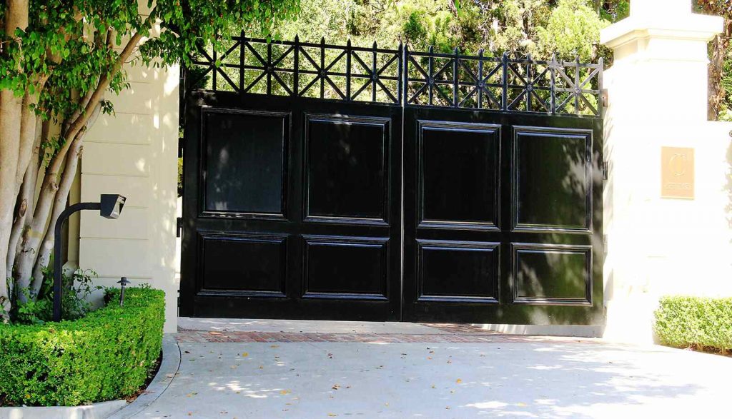 Wood paneled bifold auto entry gate