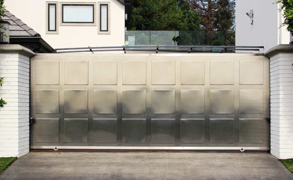 Single slide auto gate in contemporary stainless steel with stainless medallions