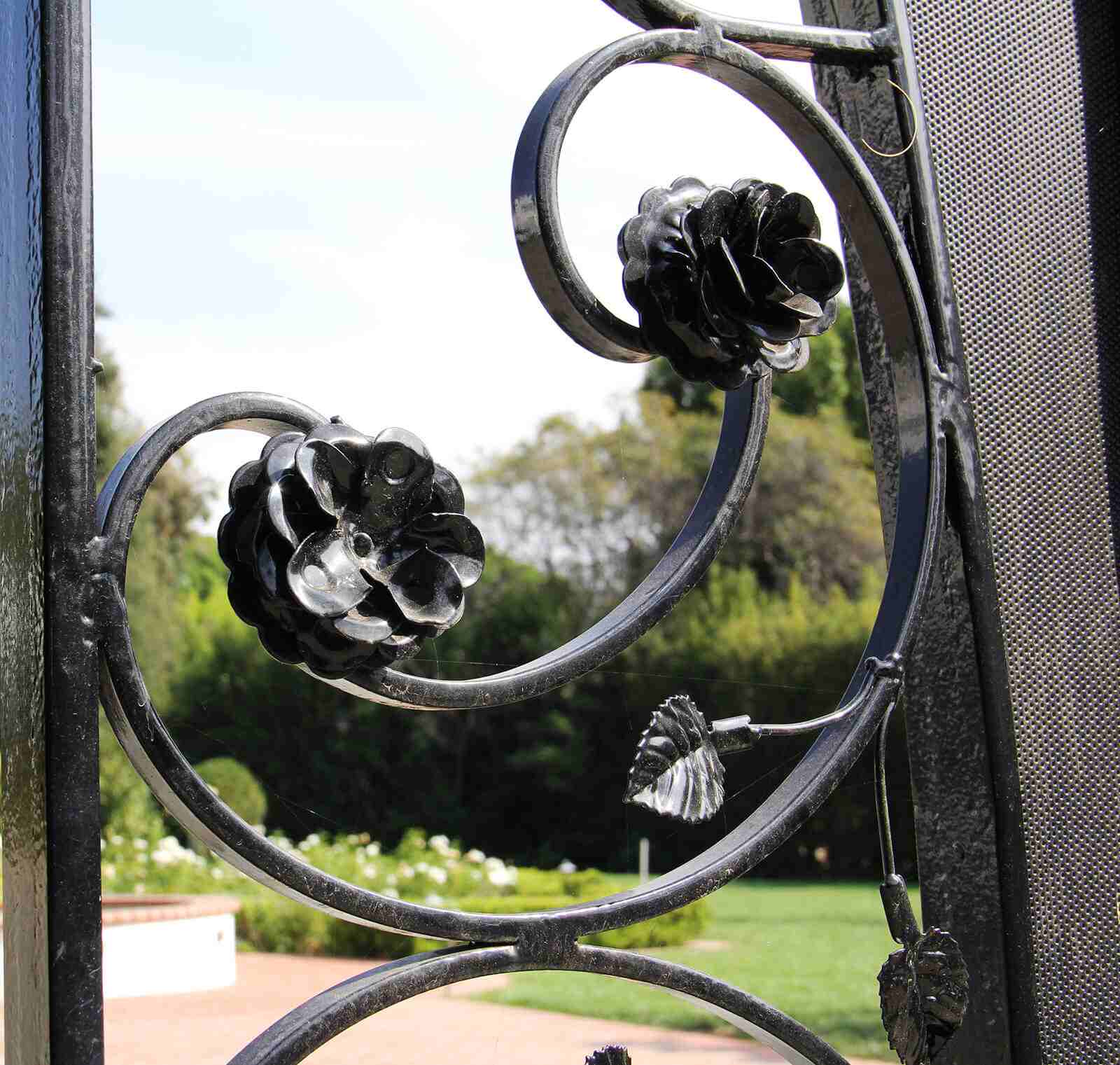 Side close up of handmade flower and leaf appliques on wrought iron gate Side close up of handmade flower and leaf appliques on wrought iron gate